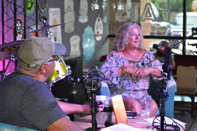 Michael interviewing a guest seated across from him, both laughing