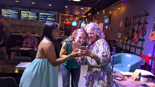 Three audience members laughing together after the show