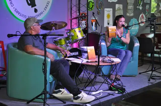 Michael and Jenna on stage, Jenna holding up the book